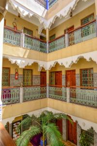 un edificio con balcones y una palmera en el medio en Hôtel Faouzi, en Marrakech