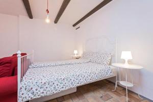 a bedroom with a white bed and a red couch at Old town studio and apartment in Vrsar