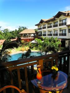 uma varanda com uma mesa e vista para um resort em Boracay Tropics Resort Hotel em Boracay