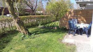 a patio with a table and chairs next to a tree at Ferienwohnung Sonneneck Poel in Timmendorf