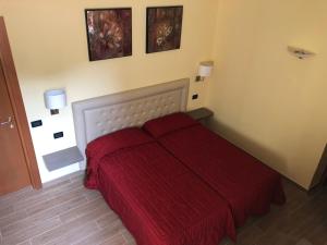a bedroom with a bed with a red blanket at Hotel Adler in Menaggio