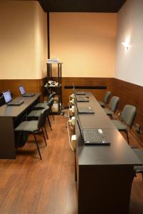 una sala de conferencias con mesas y sillas y ordenadores portátiles. en Hotel Salieri, en Legnago