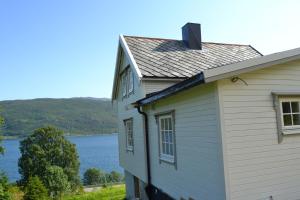 een wit huis met uitzicht op een meer bij Kvaløya Lodge in Lanes