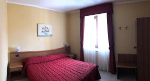a bedroom with a red bed and a window at Hotel Adler in Menaggio