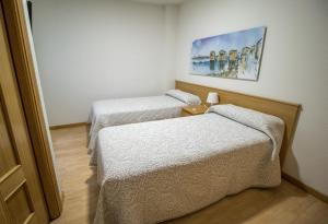 Habitación con 2 camas y una pintura en la pared. en Pension Oasis, en Zamora