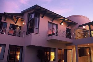 una casa bianca con finestre nere e balconi di Atlantic Waves Guest House a Città del Capo