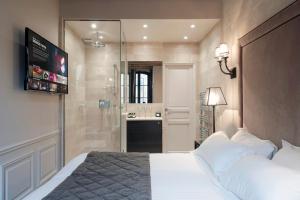 a bedroom with a large bed and a bathroom at Hôtel Le Presbytère in Paris