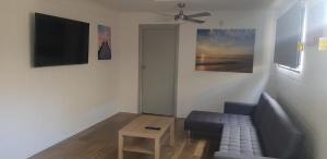 een woonkamer met een bank en een flatscreen-tv bij Breeze On Northbay 67 Elizabeth Crescent Carrickalinga in Carrickalinga