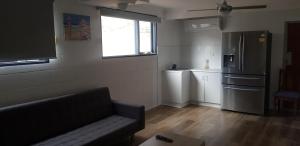 een woonkamer met een bank en een koelkast bij Breeze On Northbay 67 Elizabeth Crescent Carrickalinga in Carrickalinga