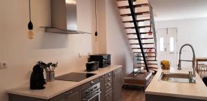 uma cozinha com uma escada em espiral numa cozinha em Casa da Mouraria em Faro