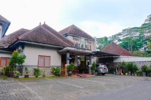 un edificio con un coche aparcado en un aparcamiento en OYO 778 Guest House Amalia Malang en Malang