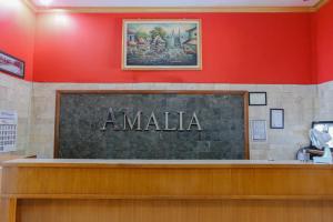 um sinal que diz amala na parede em OYO 778 Guest House Amalia Malang em Malang
