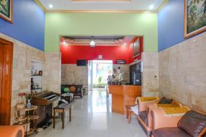 una sala de estar con paredes y sofás coloridos en OYO 778 Guest House Amalia Malang en Malang