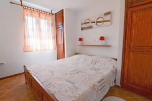 a small bedroom with a bed and a window at Cvita A2+1 in Veli Lošinj