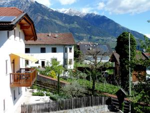 uma vista para uma casa com montanhas ao fundo em Boutique Appartamento Bacchus em Marlengo