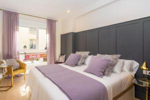 1 dormitorio con 1 cama grande con almohadas moradas en iloftmalaga Victoria 43, en Málaga
