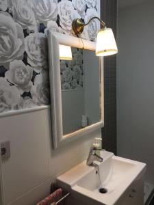 a bathroom with a sink and a mirror and a lamp at El Quinto Pino in Santibáñez del Val