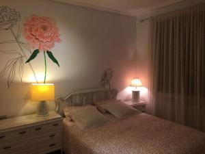 1 dormitorio con 1 cama con una flor en la pared en El Quinto Pino, en Santibáñez del Val