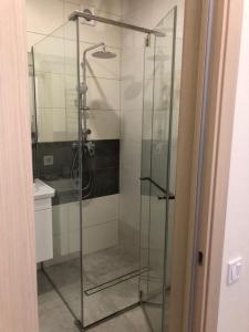 a glass shower in a bathroom with a sink at Центр Буча апартаменти подобово in Bucha