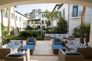 an outdoor patio with blue and white chairs at The Inn by Sea Island in Saint Simons Island