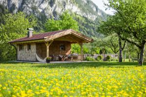una pequeña casa con un cenador en un campo de flores en Windhaghof en Kramsach