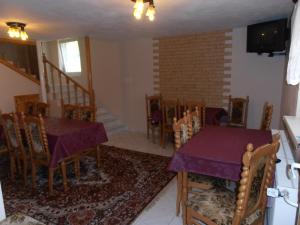 a dining room with a table and chairs and a staircase at Penzion Smrek in Habovka