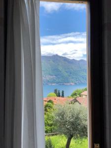 a window with a view of a lake and mountains at Hotel Adler in Menaggio