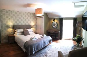 a bedroom with a bed and a desk and a window at Anglesey Hotel in Gosport