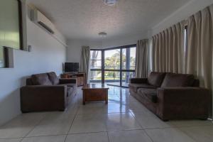 a living room with two couches and a table at Rosslyn Bay Resort Yeppoon in Yeppoon