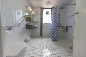 a white bathroom with a shower and a toilet at Rosslyn Bay Resort Yeppoon in Yeppoon