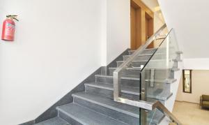 a staircase in a house with a glass railing at Treebo Trend City Inn Satara in Satara