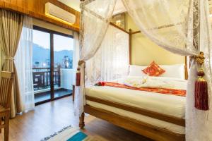 una camera con letto a baldacchino e finestra di Hotel Mala Pokhara a Pokhara