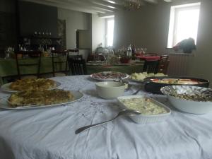 una mesa con platos de comida en un mantel blanco en Ca' Do Diao, en Onzo