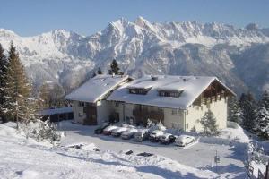 a house with cars parked in the snow at Haus Wogesa - CharmingStay in Flumserberg