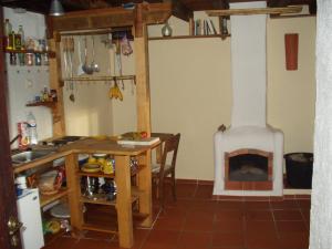 a kitchen with a fireplace in the corner of a room at Madeira-Meerblick-Haus in Estreito da Calheta