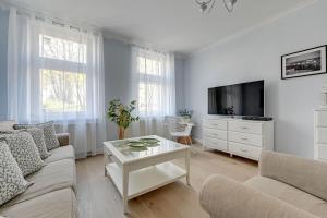 een woonkamer met een bank en een tv bij Lion Apartments - Parkowa 33Am2 z parkingiem 2 min od plaży in Sopot