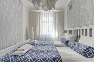 ソポトにあるLion Apartments - Parkowa 33Am2 z parkingiem 2 min od plażyのベッドルーム1室(青と白のベッド、タオル付)