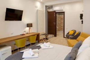 a room with a bed and a desk and chairs at LUSSUOSAMENTE Luxury B&B in Caltanissetta