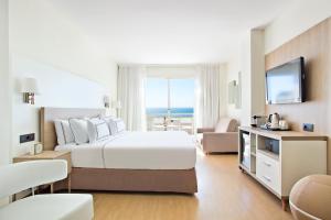 a hotel room with a large bed and a television at Melia Sitges in Sitges