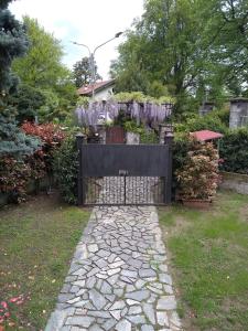 un cancello in un giardino con passerella in pietra di Casa Orisca a Lesa