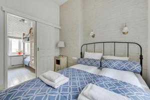 a bedroom with a bed with blue and white sheets at Lion Apartments - Scandi Love III in Sopot