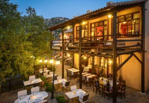 ein Restaurant mit Tischen und Stühlen vor einem Gebäude in der Unterkunft Enagron Ecotourism Village in Axós