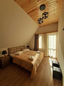 a bedroom with a large bed and a wooden ceiling at Kazbegi Inn in Stepantsminda