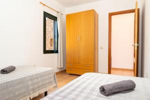 a bedroom with two beds and a wooden cabinet at Ciel y Mar in La Oliva +22 photos