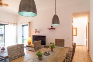 a living room with a table and chairs and two pendant lights at Ciel y Mar in La Oliva
