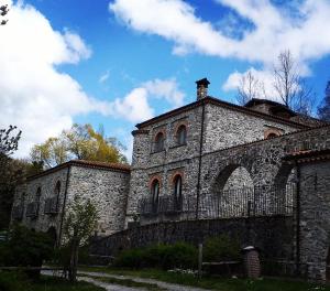 an old stone building with a fence around it at Hotel Ristorante Mulino Iannarelli in San Severino Lucano