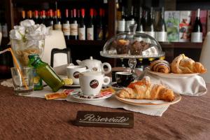 a table with croissants and cups and pastries on it at LUSSUOSAMENTE Luxury B&B in Caltanissetta