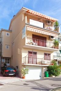 a building with a car parked in front of it at Apartments Garmaz in Podgora