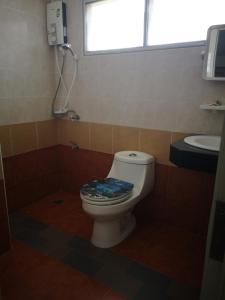 a bathroom with a toilet and a sink at Sab Suwarn Mansion in Suphan Buri