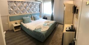 um quarto com uma cama com almofadas azuis em Hotel Grand Heykel em Bursa